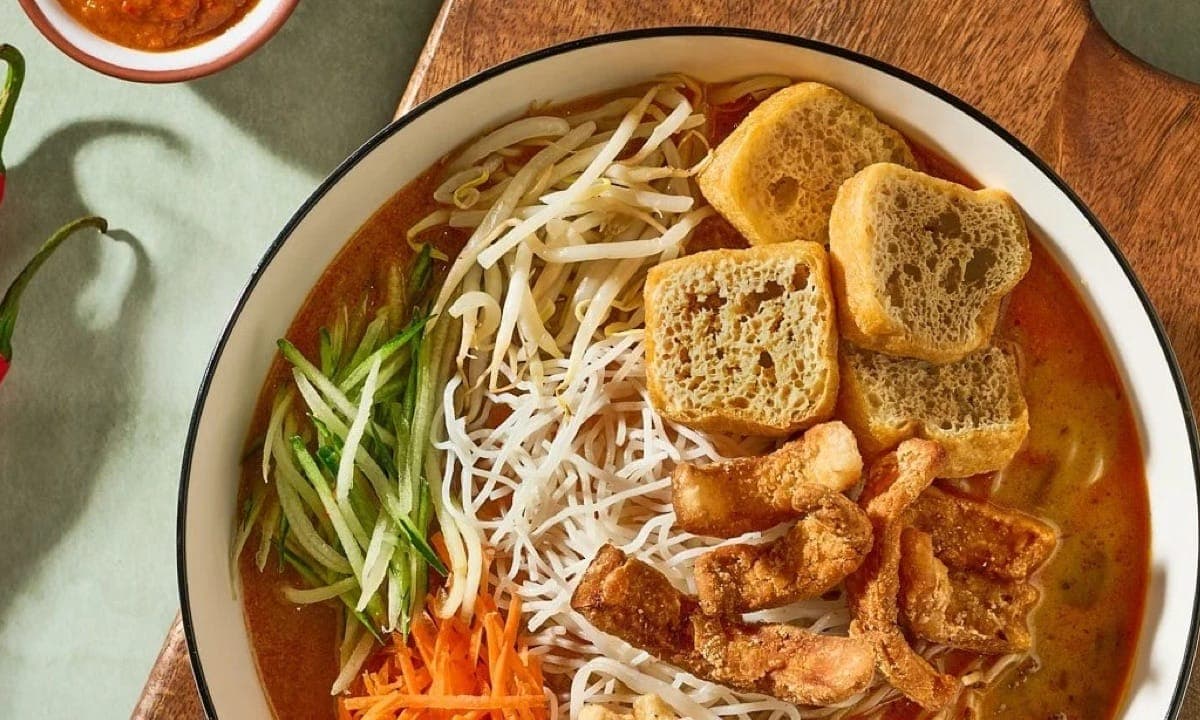A bowl of Savor Sarawak laksa with tofu puffs and bean sprouts